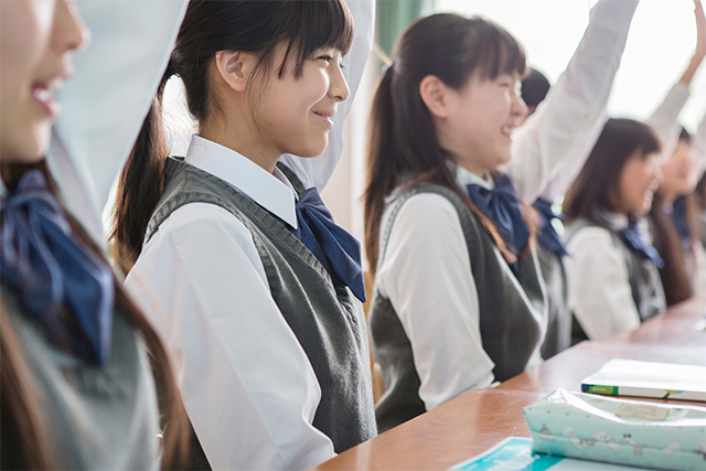 手を挙げている女子高生