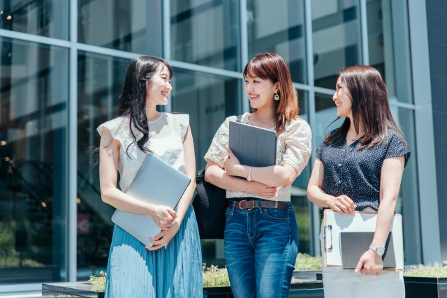 笑顔で話す3人の女子大生