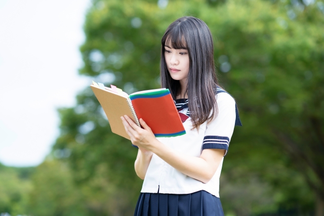 付箋のついている参考書を読む女の子