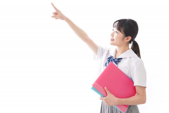 左上を指さしている制服を着た女の子