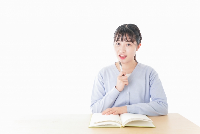 ノートを開いて考え事をしている女の子