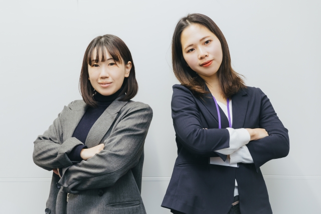 腕を組んでいる女性×2