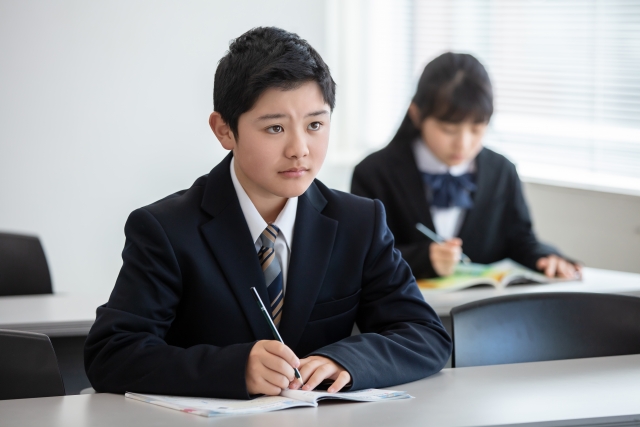 勉強しながら前を向いている男の子