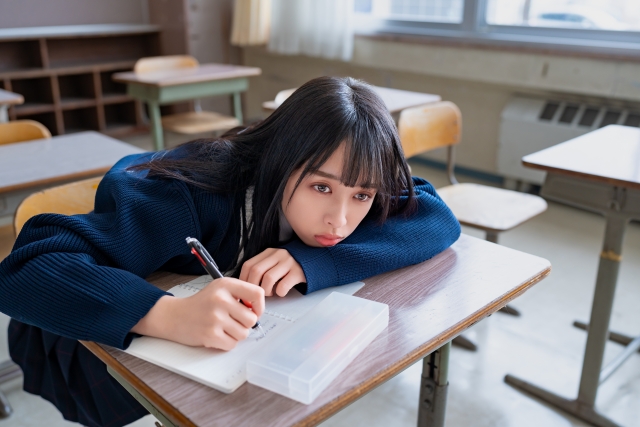 勉強中に机に顎を乗せる女の子