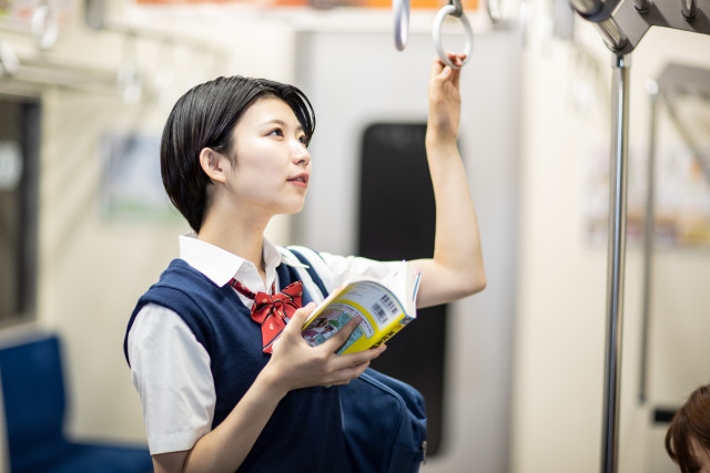 電車で勉強する女子生徒
