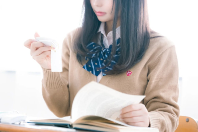 単語帳を見ながら勉強している女子学生