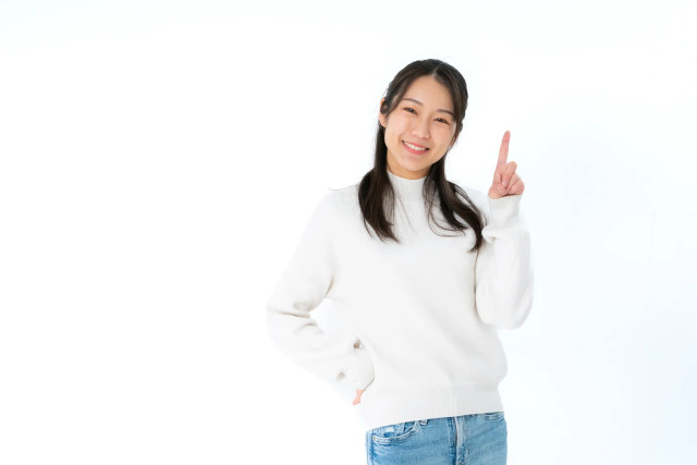 人差し指を立てて笑顔の女性