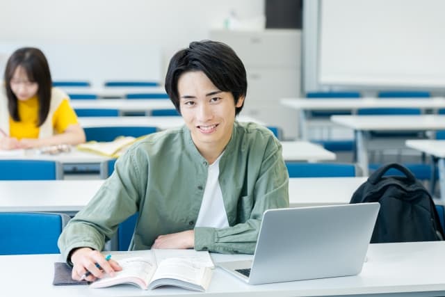 男子生徒が笑顔で勉強している様子
