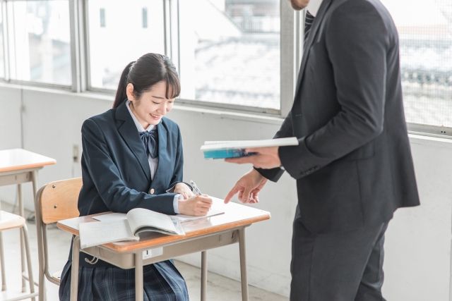 先生に説明をしてもらっている女子高生